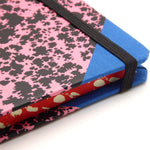 Edge of pink patterned notebook with blue corner and red sponged page edges.  Emilio Braga Cloud Print A5 Notebook - Pink - Leaves Stationery Store