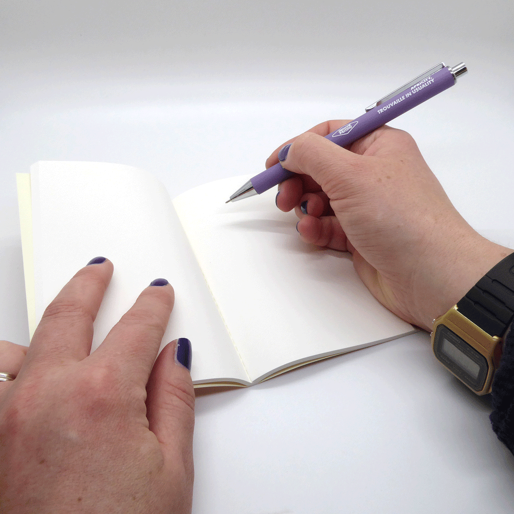 Hands writing in plain paged notebook